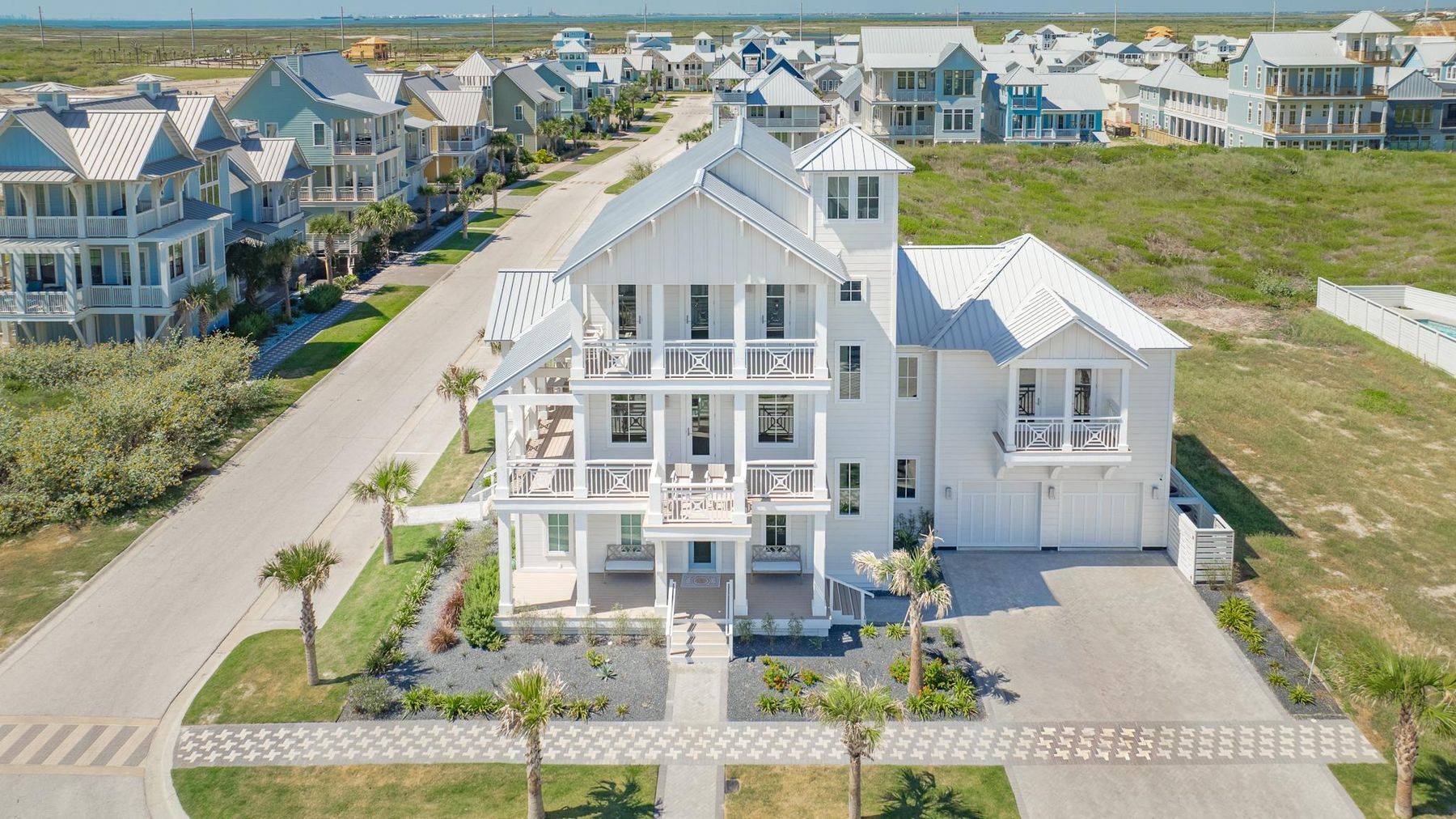 An elevated three-story Christensen coastal home with stacked porches, seen from above