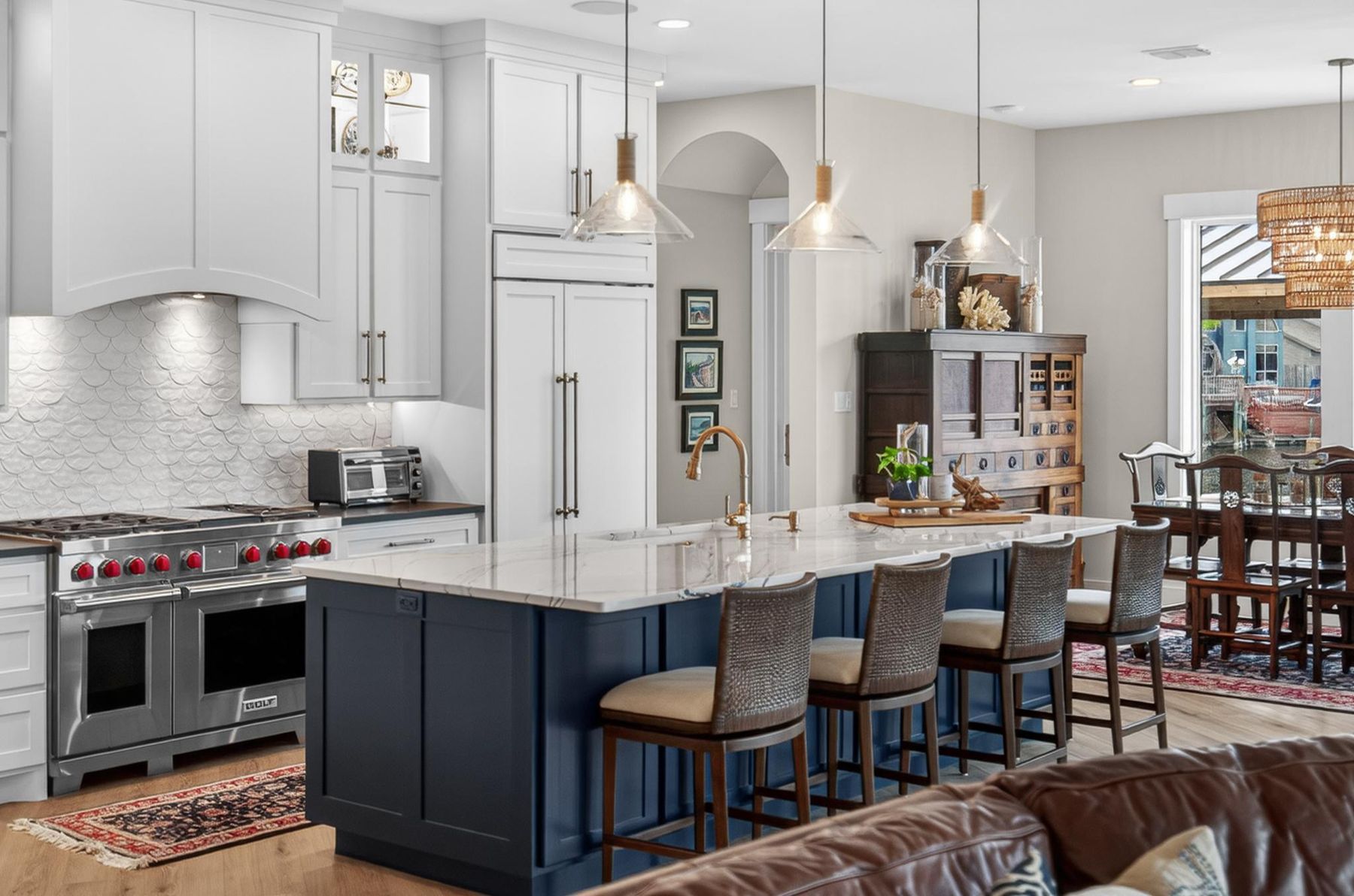 Kitchen with a navy island and brass fixtures