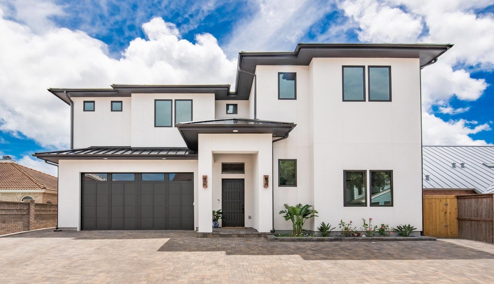 A modern white stucco custom home with a standing-seam metal roof on Padre Island