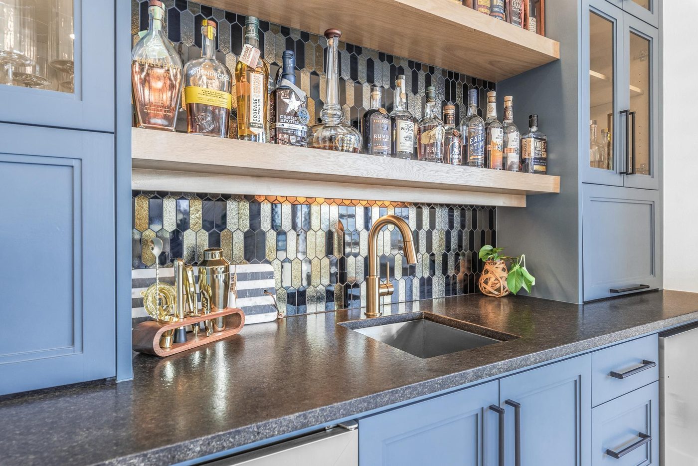 Built-in bar with blue cabinetry, glass shelving and a wine rack