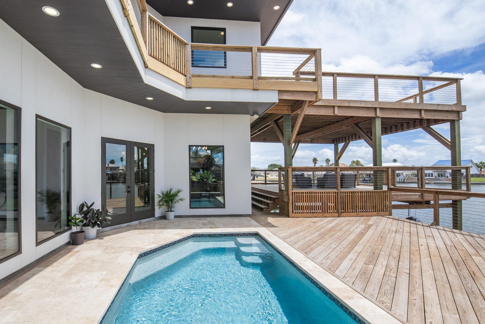 A resort-style pool and timber deck overlooking the bay at a Christensen custom home