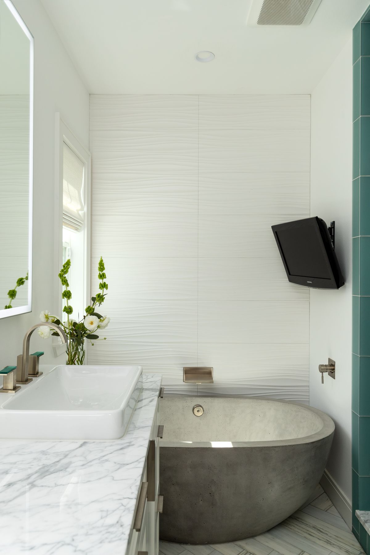 Freestanding stone soaking tub against marble