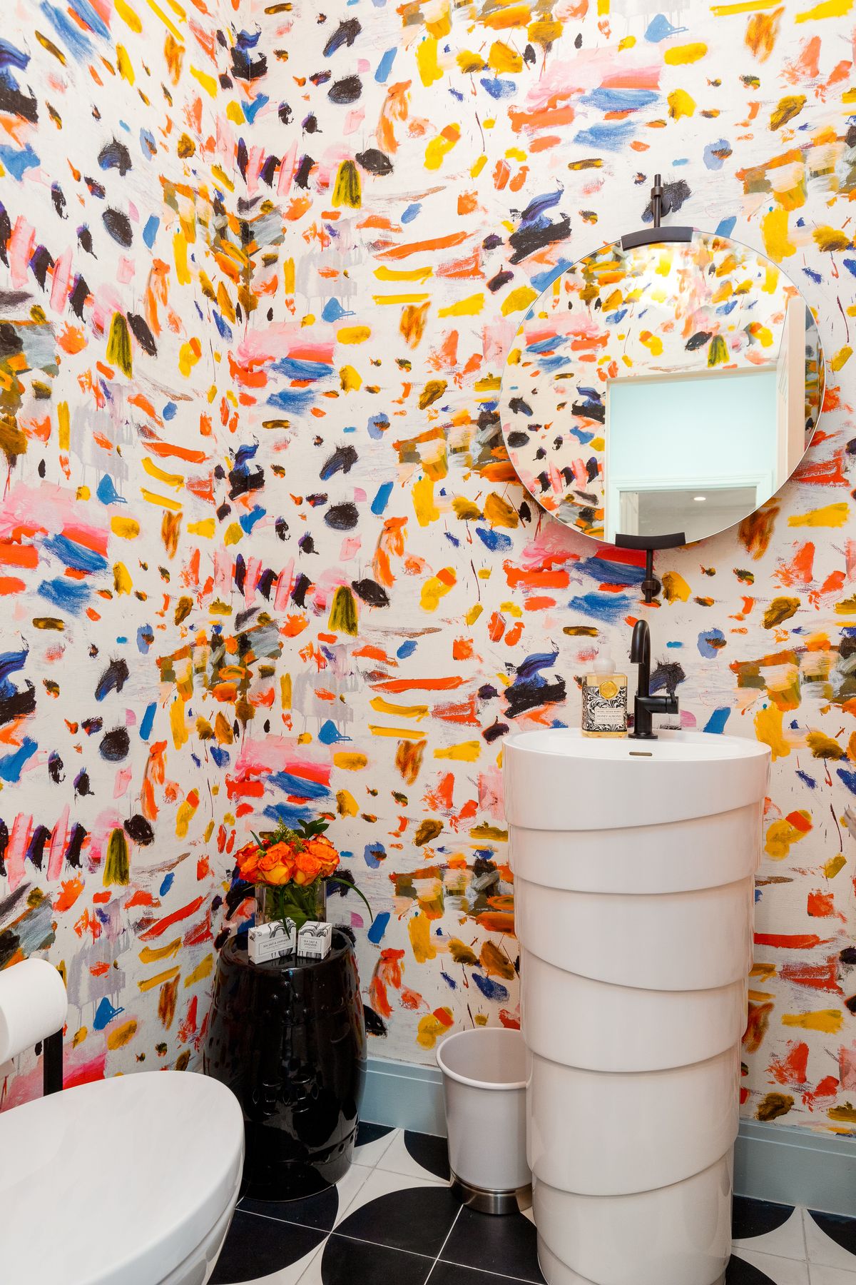 Powder room with bold painted wallpaper and a sculptural basin