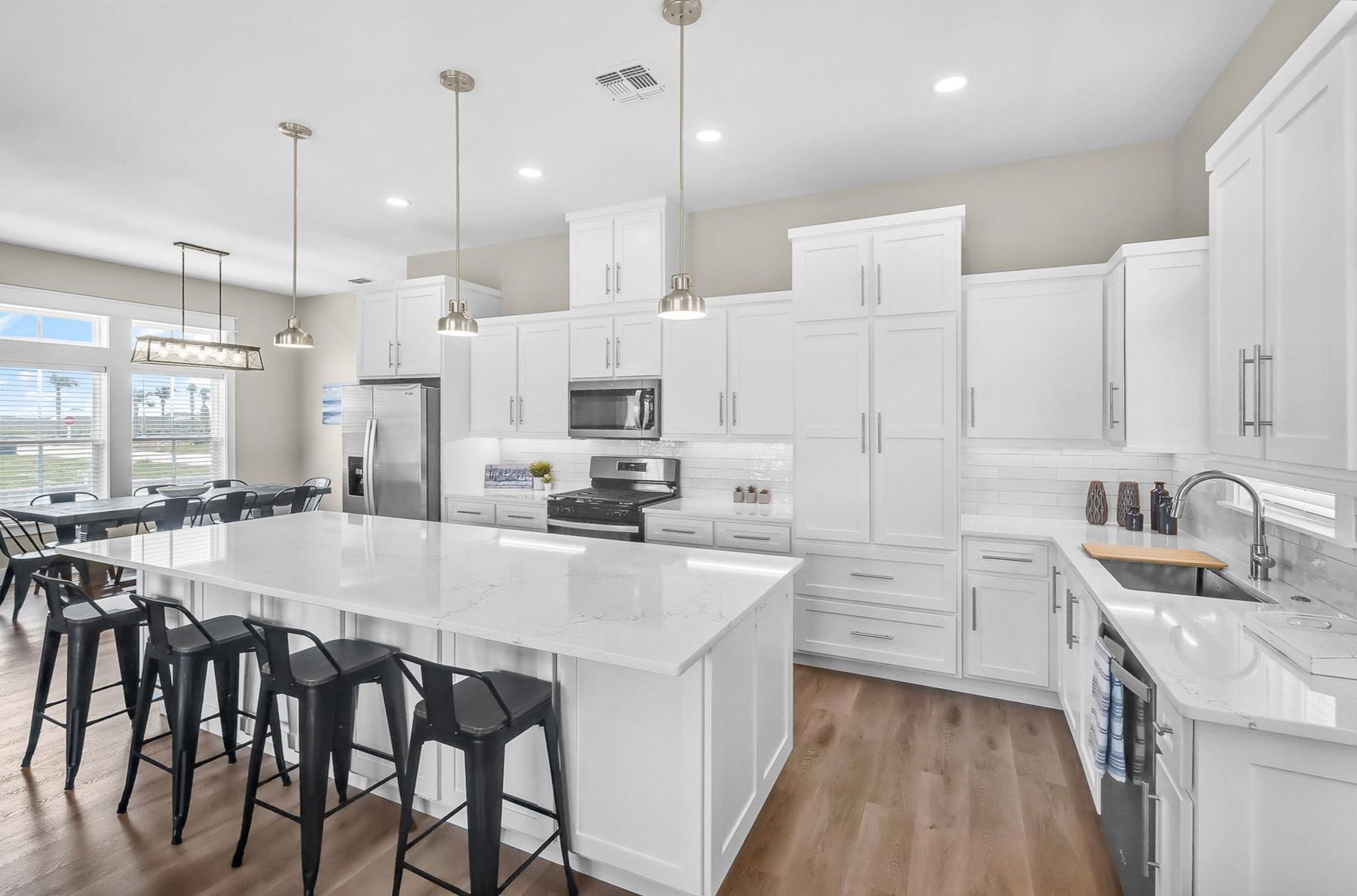White kitchen with a large island and black barstools